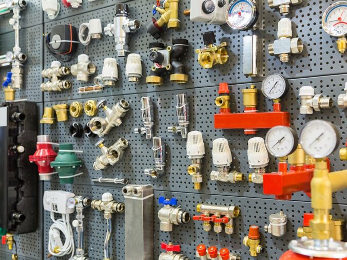 Brass pipe connectors and valves in a wall in a plumbing supply store